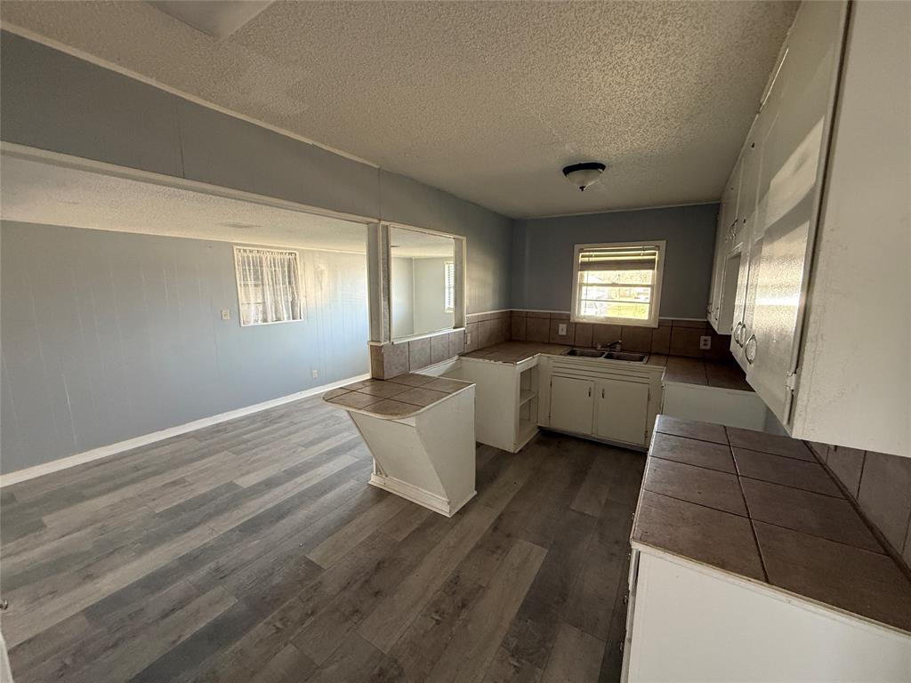 501 Needham Street Coleman, TX 76834 - Photo 4 of 16 a view of an empty room with window and wooden floor