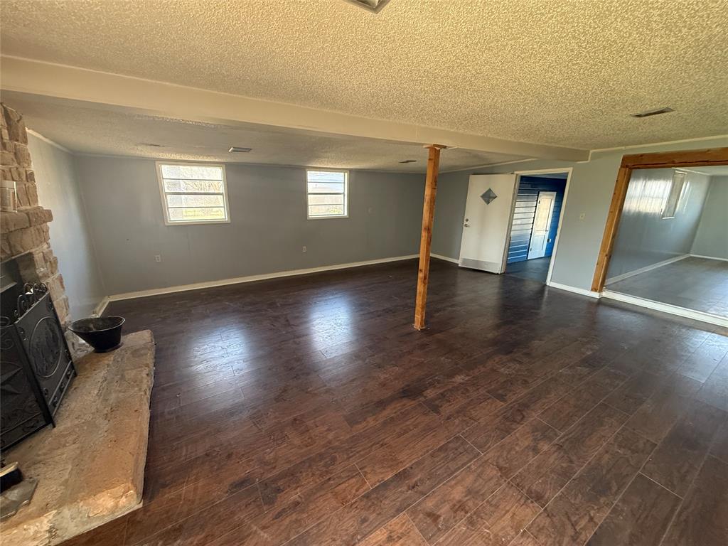501 Needham Street Coleman, TX 76834 - Photo 8 of 16 a view of an empty room with wooden floor and a window