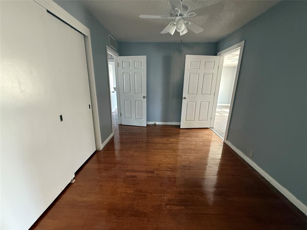 501 Needham Street Coleman, TX 76834 - Photo 9 of 16 an empty room with wooden floor and windows
