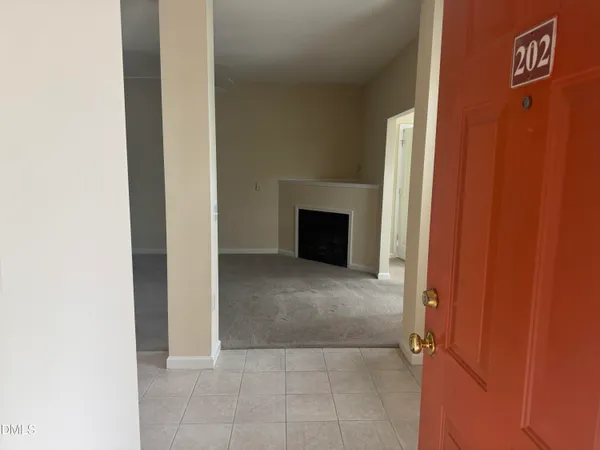 a view of an empty room with a fireplace and a window