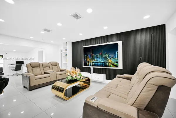 a living room with furniture a flat screen tv and a dining table