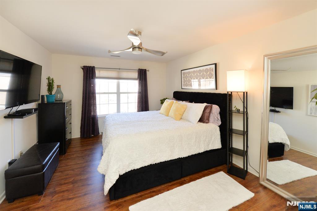 20 Parkside Court Wayne, NJ 07470 - Photo 13 of 22 a bed sitting in a bedroom next to a window with pc on the table