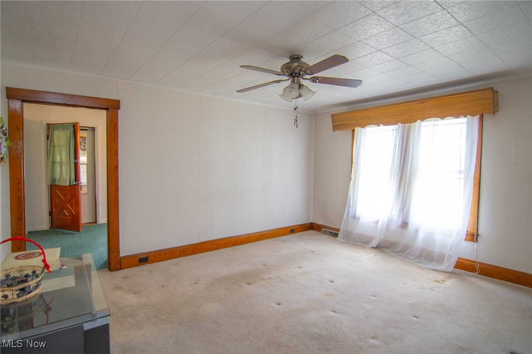 56260 Davis Road Bellaire, OH 43906 - Photo 29 of 44 Spare room with baseboards, ceiling fan, visible vents, and carpet