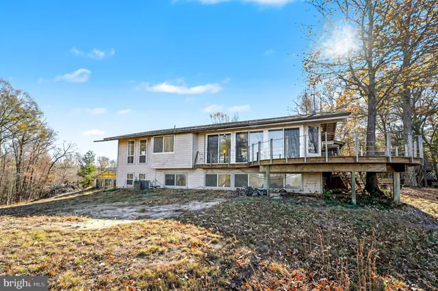a house that has a big yard with plants and large trees