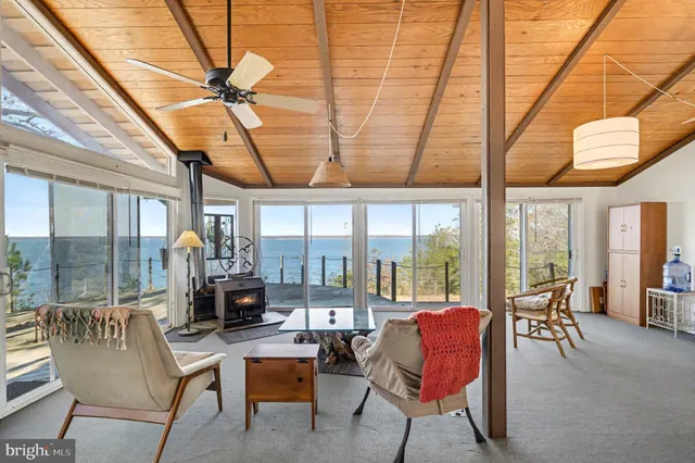 a living room with furniture a floor to ceiling window and a table
