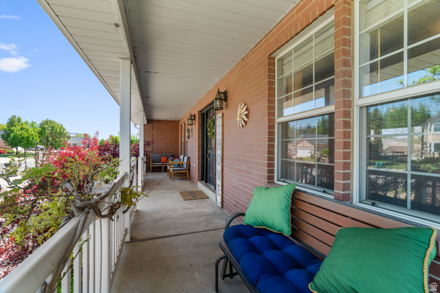 5727 South 3550th Street West Roy, UT 84067 - Photo 7 of 49 Covered front porch featuring a concrete surface, white railings, and brick exterior