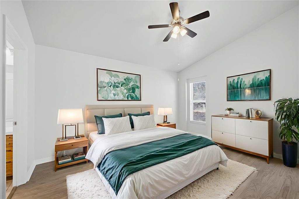 13323 Bainbridge Way Spring Hill, FL 34609 - Photo 11 of 33 a bedroom with a large bed and a chandelier