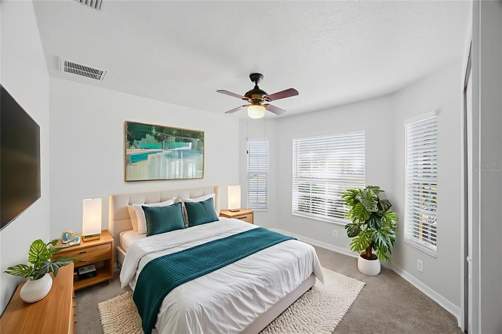 13323 Bainbridge Way Spring Hill, FL 34609 - Photo 16 of 33 a bedroom with a bed and a chandelier