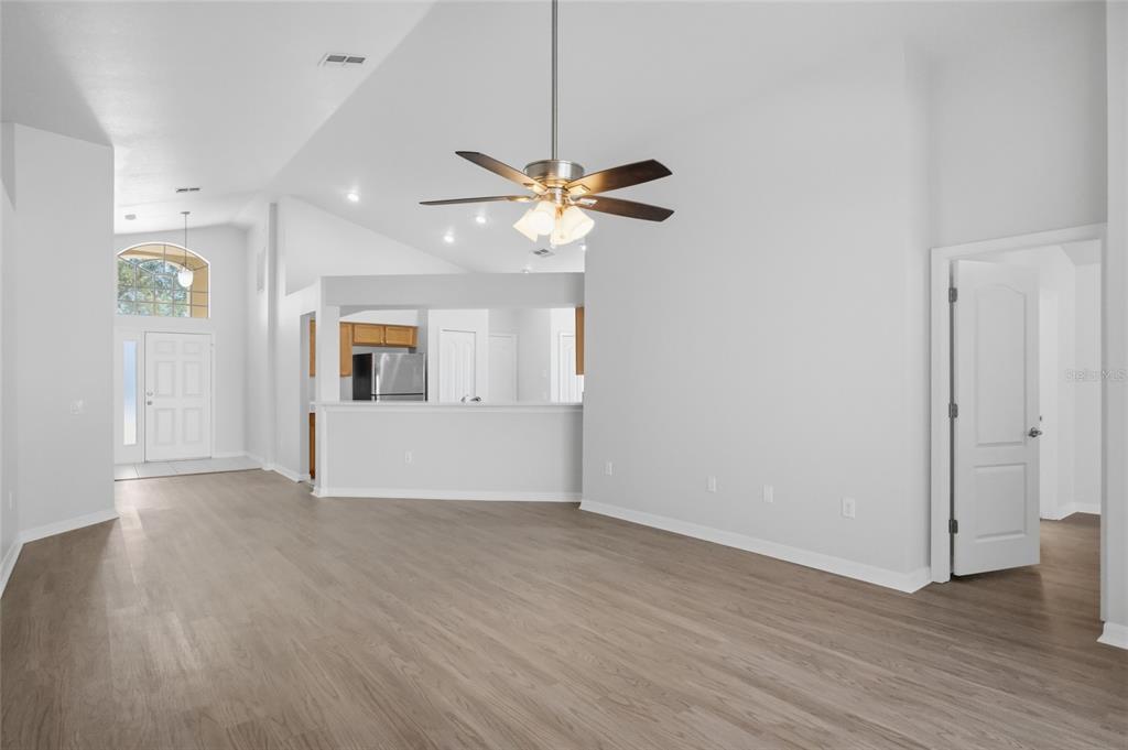 13323 Bainbridge Way Spring Hill, FL 34609 - Photo 5 of 33 a view of a room with wooden floor and a ceiling fan