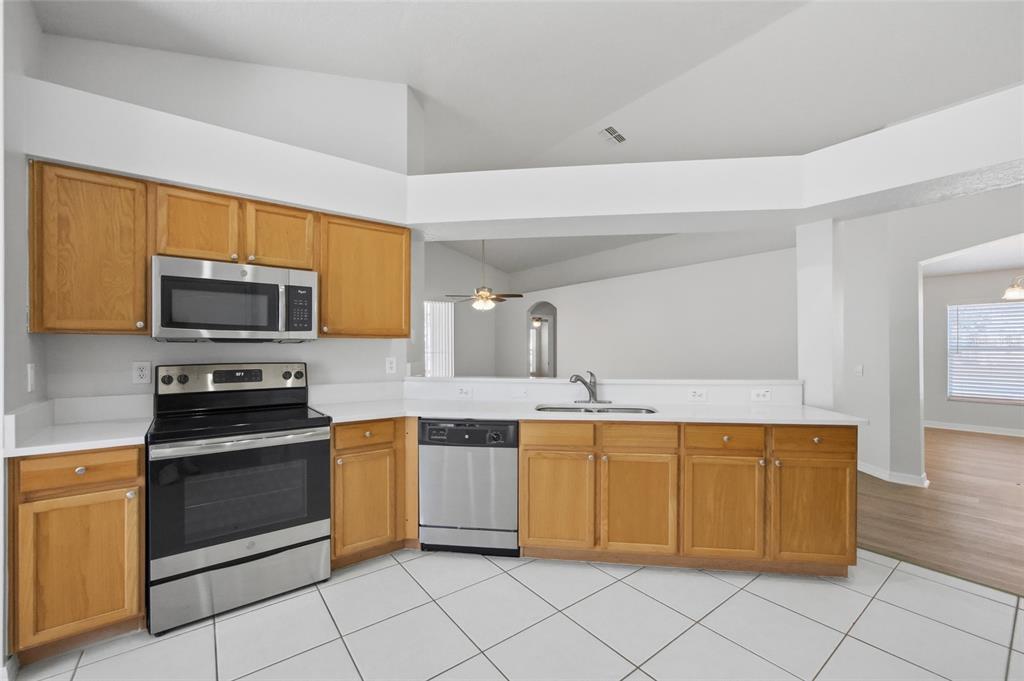 13323 Bainbridge Way Spring Hill, FL 34609 - Photo 6 of 33 a kitchen with stainless steel appliances a stove sink and microwave