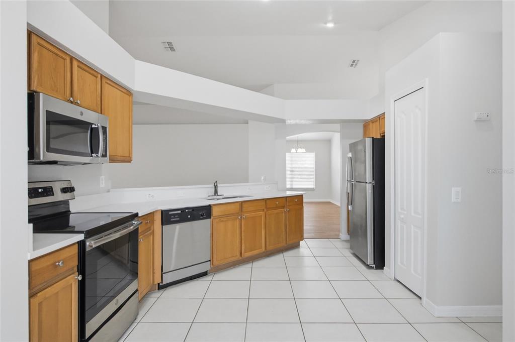13323 Bainbridge Way Spring Hill, FL 34609 - Photo 7 of 33 a kitchen with a sink a stove top oven and cabinets