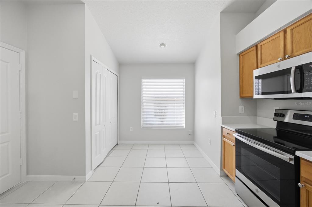 13323 Bainbridge Way Spring Hill, FL 34609 - Photo 8 of 33 a kitchen with granite countertop a stove a sink and a microwave