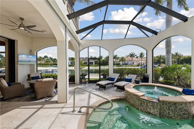 a living room with patio furniture and a floor to ceiling window