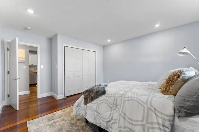 a bedroom with a bed and wooden floor