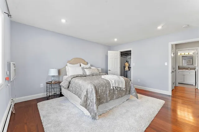 a spacious bedroom with a bed and wooden floor