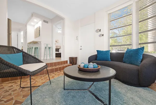 a living room with furniture a rug and a window