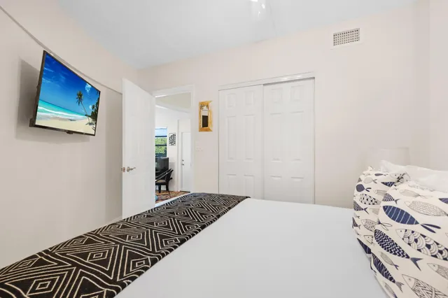 a kitchen with granite countertop a refrigerator sink stove and white cabinets