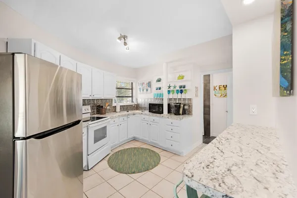 a kitchen with white cabinets and white appliances