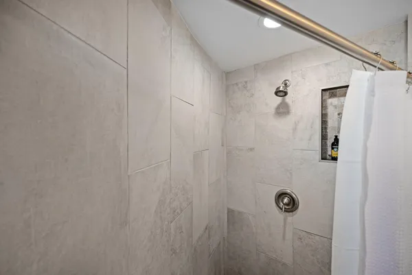 a kitchen with a refrigerator and white cabinets