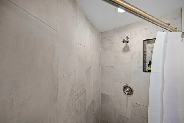 a kitchen with a refrigerator and white cabinets