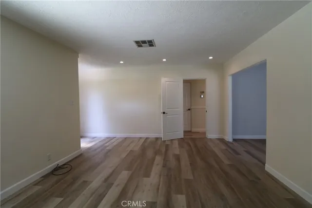 a view of an empty room with wooden floor