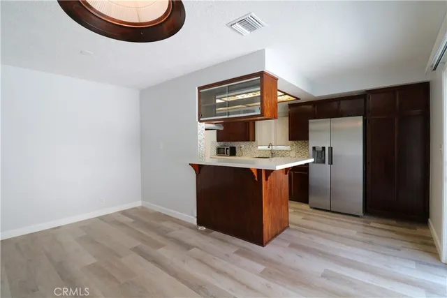 a kitchen with stainless steel appliances granite countertop a sink a stove a refrigerator and island