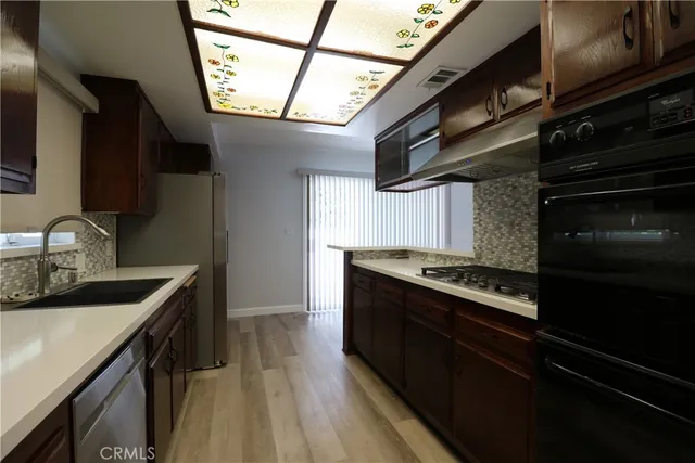 a kitchen with wooden cabinets and a stove top oven