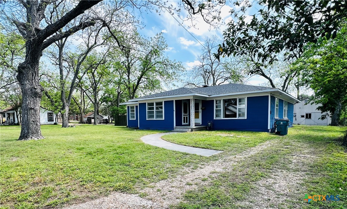a front view of a house with a yard and trees