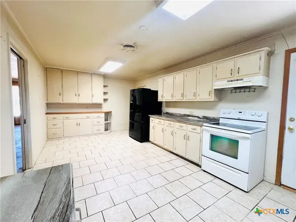 a kitchen with a stove top oven sink and cabinets