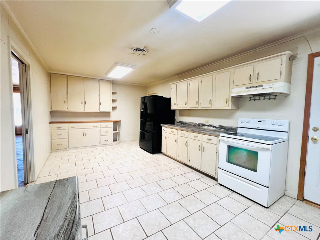 1307 West Main Street Cameron, TX 76520 - Photo 14 of 24 a kitchen with a stove top oven sink and cabinets