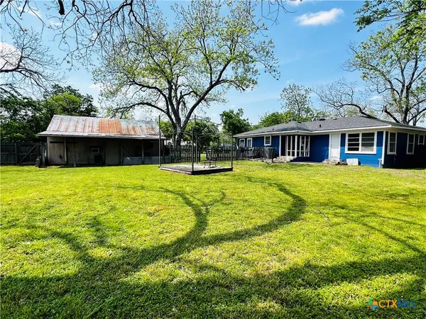 a view of swimming pool with lawn chairs and plants