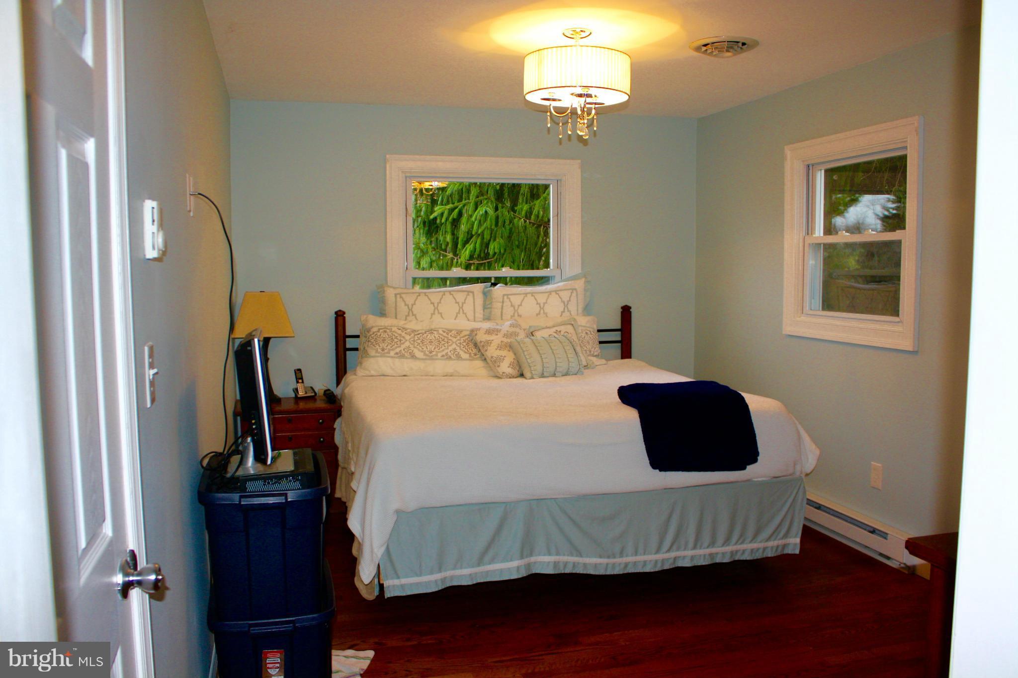28400 Clarksburg Road Damascus, MD 20872 - Photo 8 of 16 a bedroom with a bed and wooden floor
