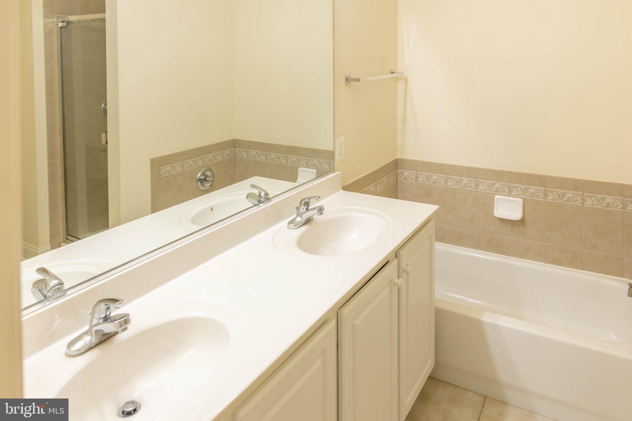 12824 Clarksburg Square Road, Unit 105 Clarksburg, MD 20871 - Photo 79 of 96 Elegant dual-sink bathroom retreat.