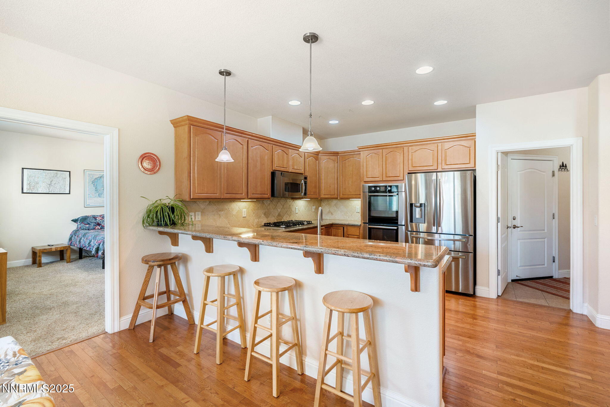 306 San Roma Drive Dayton, NV 89403 - Photo 17 of 46 a kitchen with stainless steel appliances granite countertop a refrigerator a stove top oven a sink dishwasher and a dining table with wooden floor