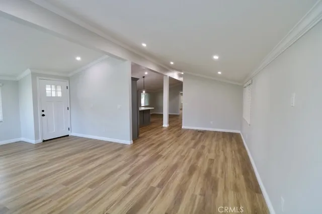 a view of an empty room with wooden floor
