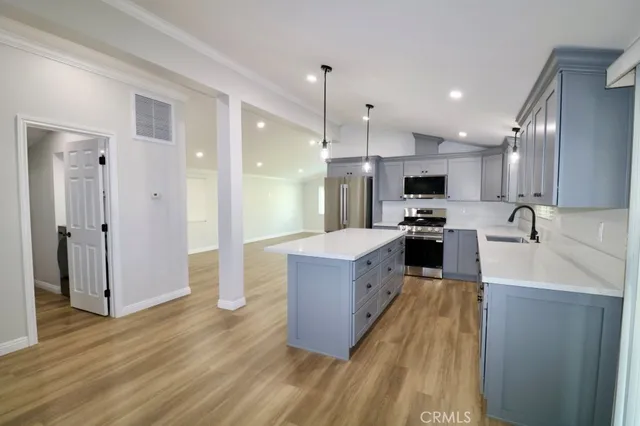 a large kitchen with stainless steel appliances lots of counter space and a sink