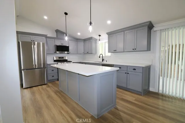 a kitchen with kitchen island a sink stainless steel appliances and cabinets