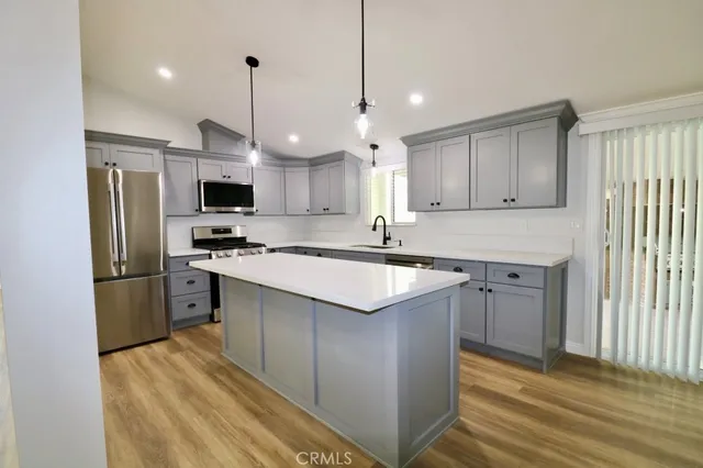 a kitchen with kitchen island a sink stainless steel appliances and cabinets