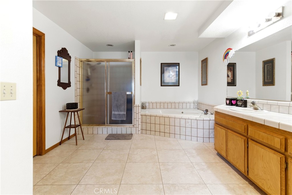 11468 Kiowa Road Apple Valley, CA 92308 - Photo 12 of 73 a spacious bathroom with a bathtub shower sink and mirror
