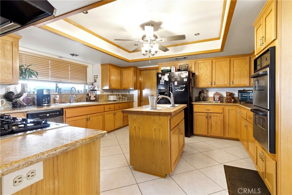 11468 Kiowa Road Apple Valley, CA 92308 - Photo 21 of 73 a kitchen with a sink a counter top space appliances and cabinets