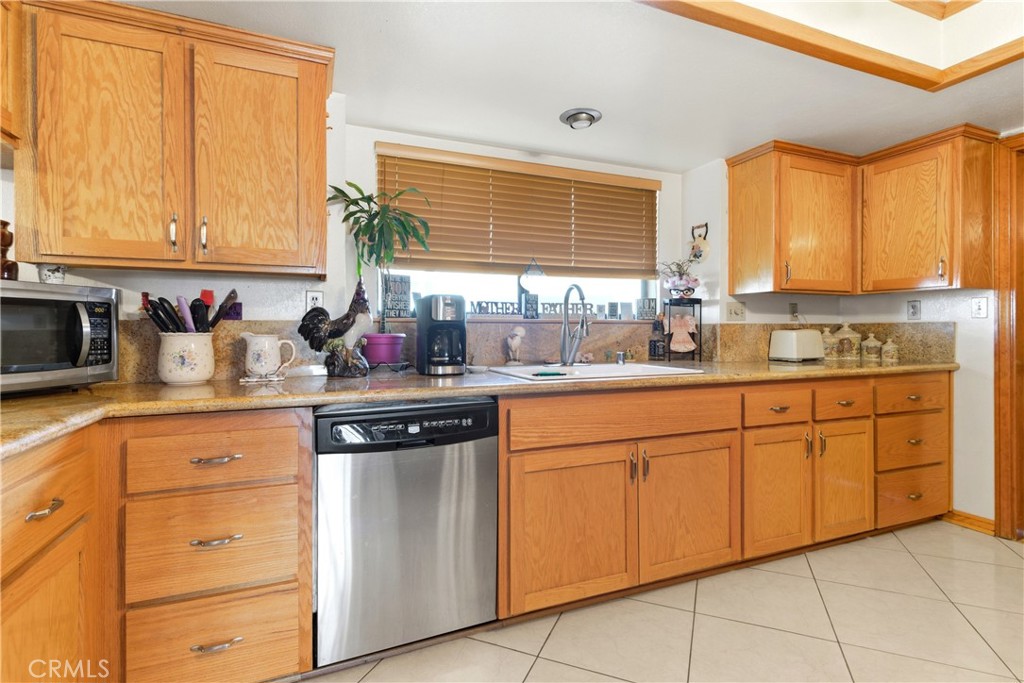 11468 Kiowa Road Apple Valley, CA 92308 - Photo 23 of 73 a kitchen with granite countertop cabinets sink and a window