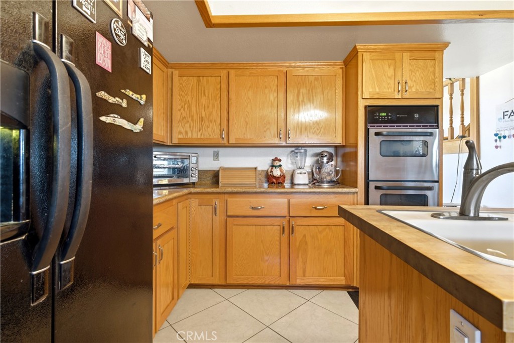 11468 Kiowa Road Apple Valley, CA 92308 - Photo 24 of 73 a kitchen with stainless steel appliances granite countertop a refrigerator sink and cabinets