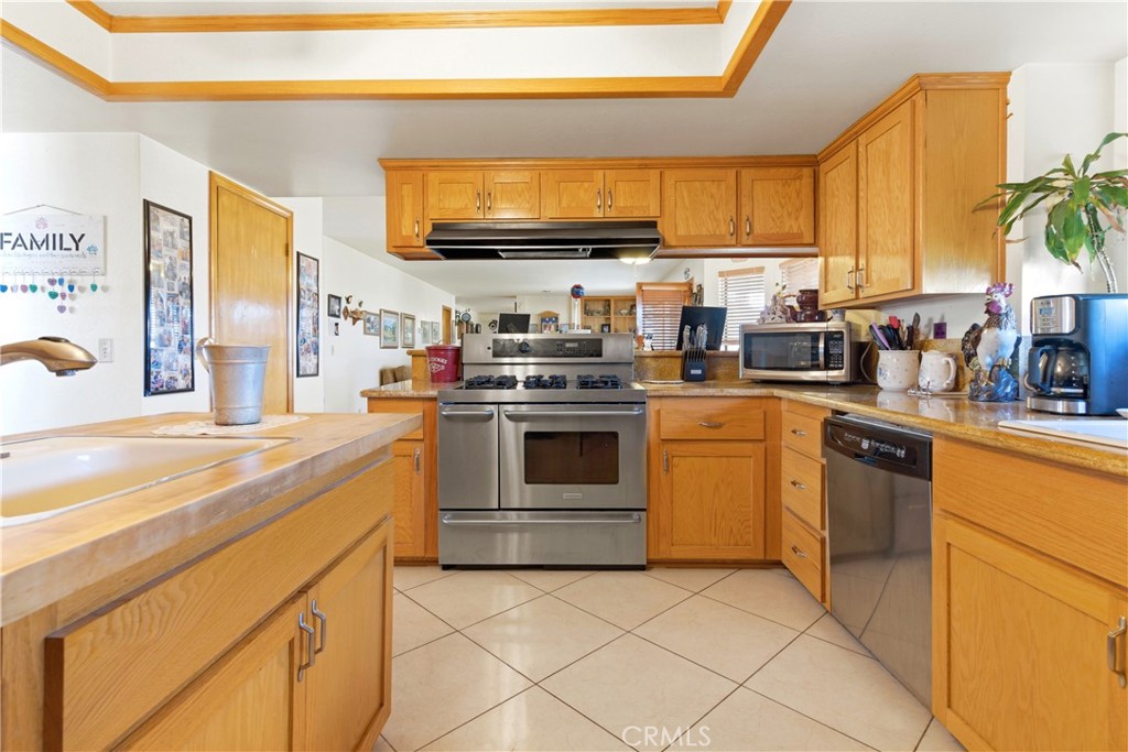 11468 Kiowa Road Apple Valley, CA 92308 - Photo 26 of 73 a kitchen with stainless steel appliances granite countertop a stove a sink and a microwave