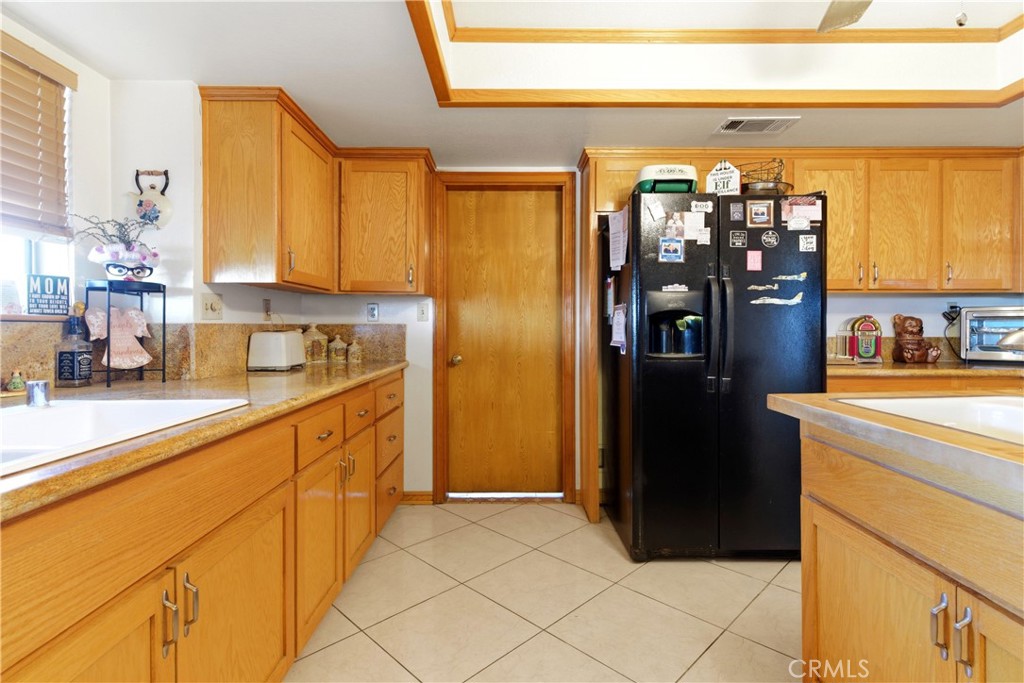 11468 Kiowa Road Apple Valley, CA 92308 - Photo 27 of 73 a kitchen with stainless steel appliances granite countertop a refrigerator and a sink