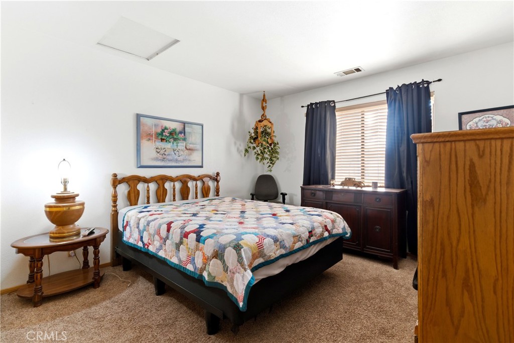 11468 Kiowa Road Apple Valley, CA 92308 - Photo 42 of 73 a bedroom with a bed lamp and window