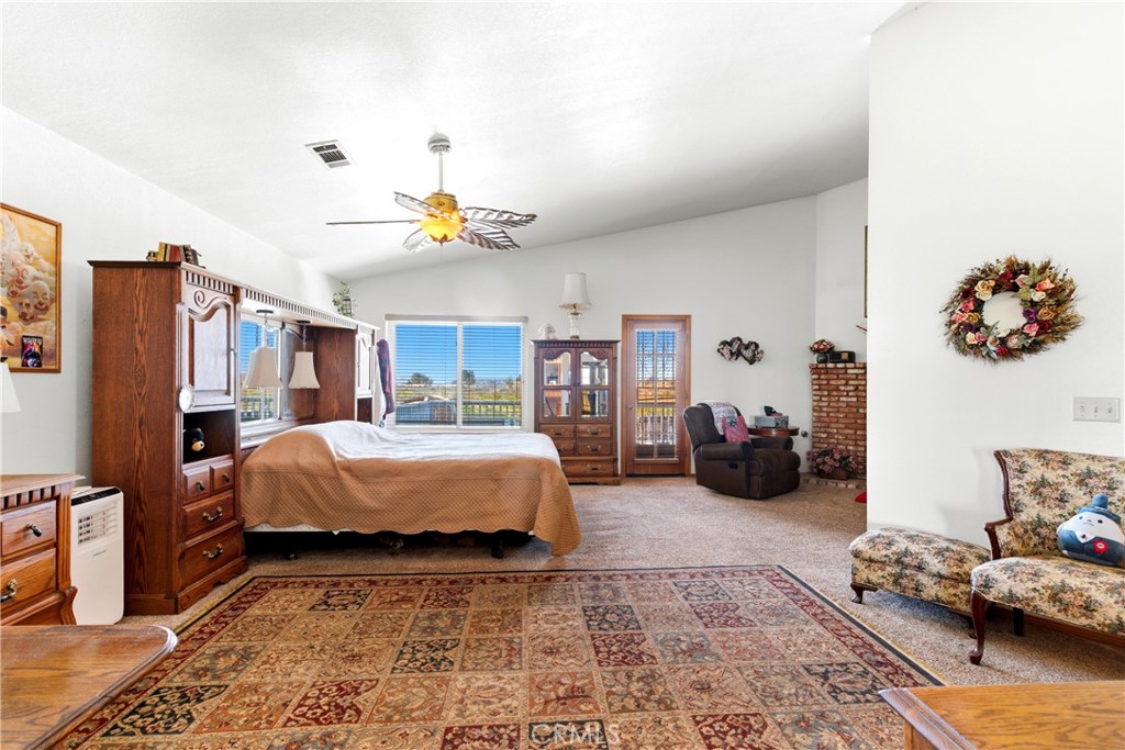 11468 Kiowa Road Apple Valley, CA 92308 - Photo 51 of 73 a bedroom with bed and a chandelier