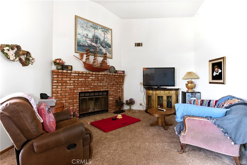 11468 Kiowa Road Apple Valley, CA 92308 - Photo 52 of 73 a living room with furniture a flat screen tv and a fireplace