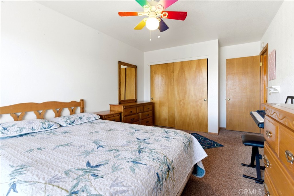 11468 Kiowa Road Apple Valley, CA 92308 - Photo 58 of 73 a bedroom with a bed and a chandelier