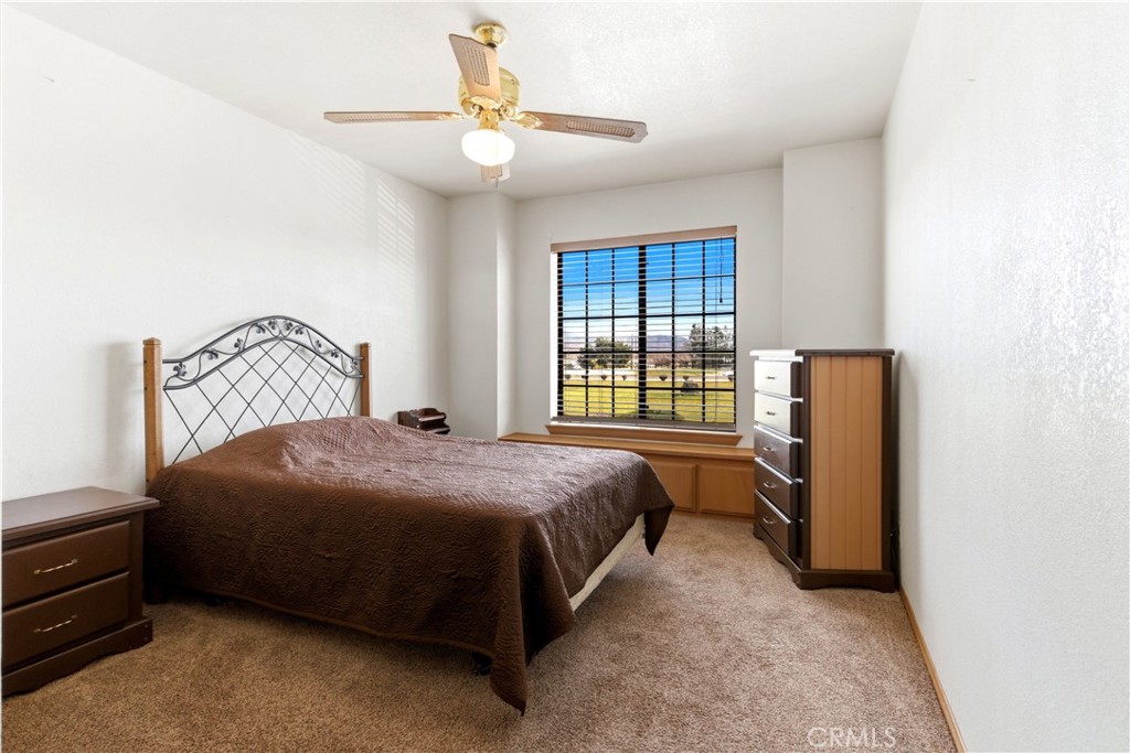 11468 Kiowa Road Apple Valley, CA 92308 - Photo 59 of 73 a bedroom with a bed and a chandelier