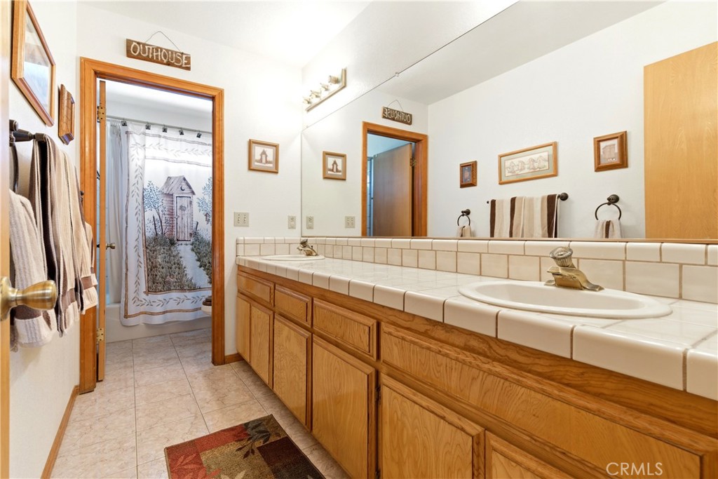 11468 Kiowa Road Apple Valley, CA 92308 - Photo 65 of 73 a spacious bathroom with a double vanity sink a mirror and a shower